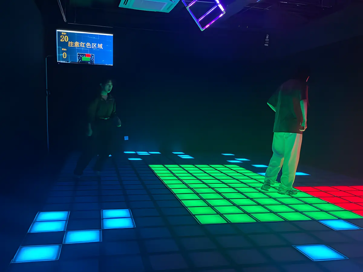 Two players standing on a green safe zone, with blue tiles left to clear across the dark floor